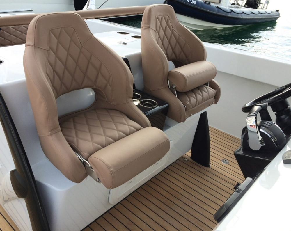 Diamond-Stitched Marine Vinyl Seats on Luxury Yacht Close-up of tan diamond-stitched marine vinyl helm seats on a yacht deck
