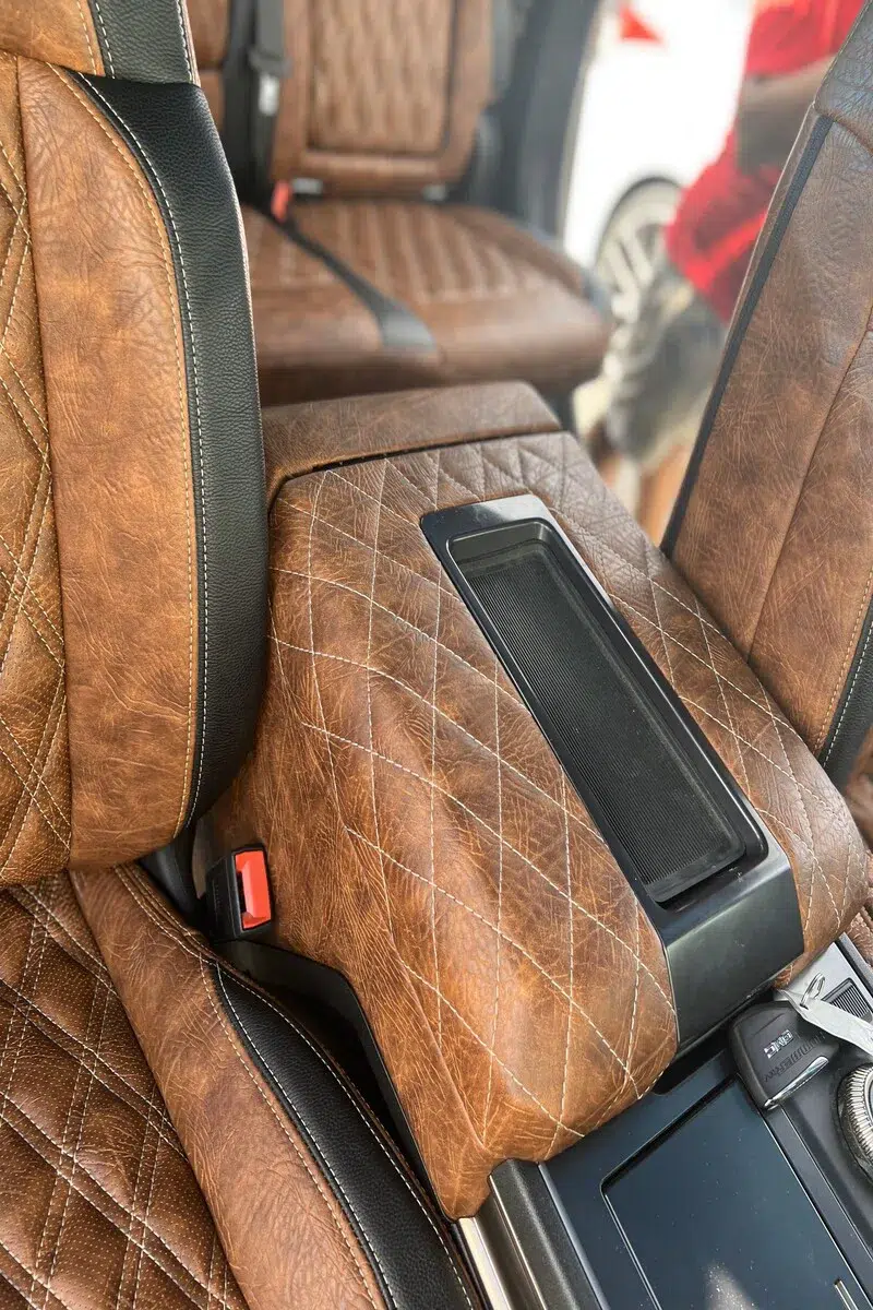 Distressed leather King Ranch upholstery installed on Hummer EV seats, center console, armrest, and door panels with custom stitching