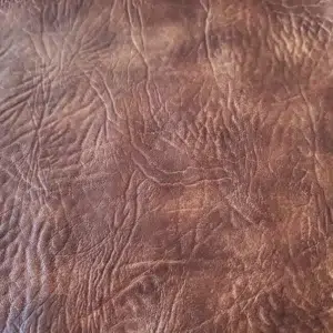 Distressed leather King Ranch upholstery vinyl in Light Tobacco Brown with rugged grain texture