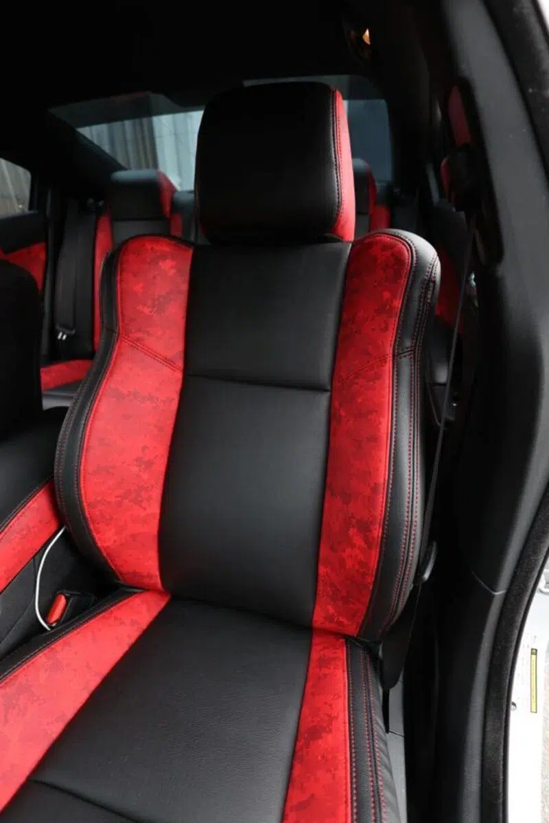 Sport car bucket seats featuring High-Octane Ruby digital camo faux leather bolsters and smooth black leather inserts.